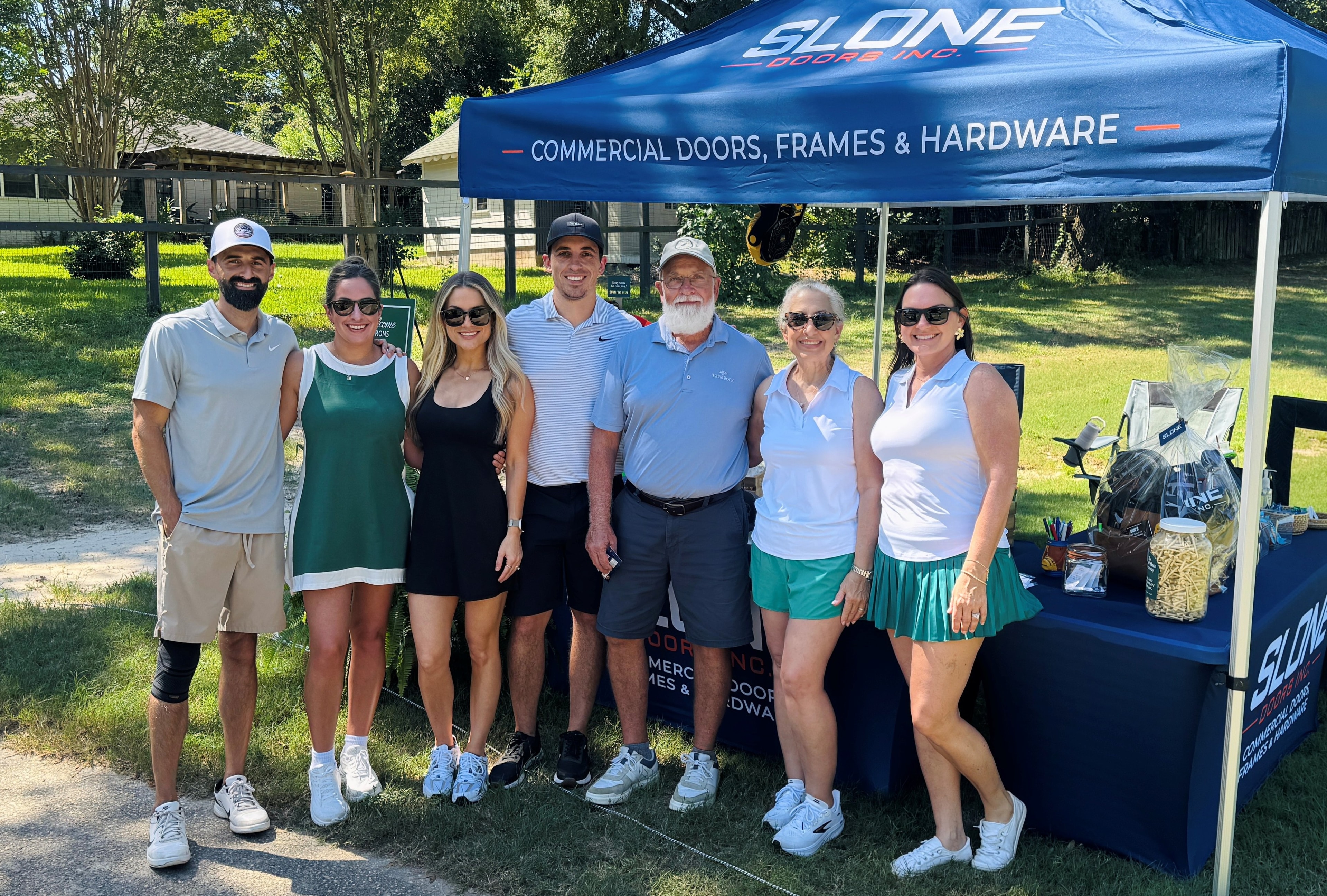 Slone Doors team and tournament participants at the company's sponsor booth during the 2026 ABC North Florida Golf Tournament.